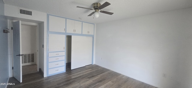 13816 N 103rd Ave, Sun City, AZ 85351 - unfurnished bedroom featuring a textured ceiling, a closet, visible vents, and dark wood-style flooring