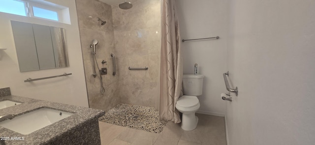 bathroom featuring a tile shower, vanity, and toilet