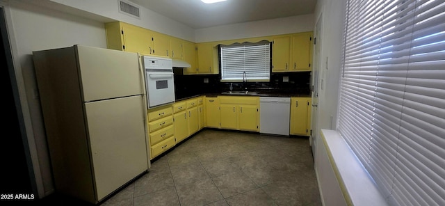 13816 N 103rd Ave, Sun City, AZ 85351 - kitchen with white appliances, dark countertops, cream cabinets, under cabinet range hood, and a sink