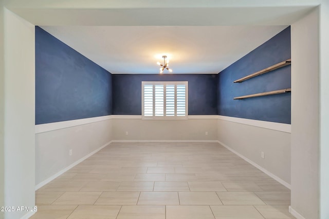 unfurnished room with a notable chandelier