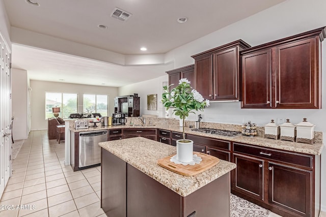 27105 W Marco Polo Rd, Buckeye, AZ 85396 - kitchen with appliances with stainless steel finishes, a peninsula, light stone counters, light tile patterned floors, and recessed lighting