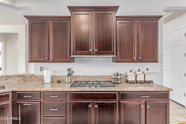27105 W Marco Polo Rd, Buckeye, AZ 85396 - kitchen with stainless steel gas stovetop, light tile patterned flooring, light stone countertops, and dark brown cabinetry