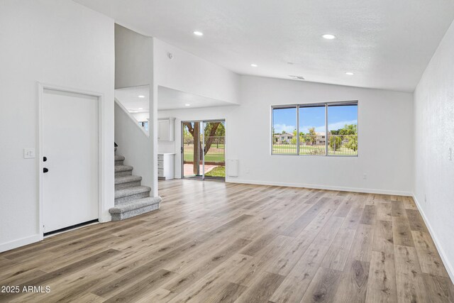 1236 S Boulder St Unit C, Gilbert, AZ 85296 - unfurnished living room featuring vaulted ceiling, stairway, light wood finished floors, and recessed lighting