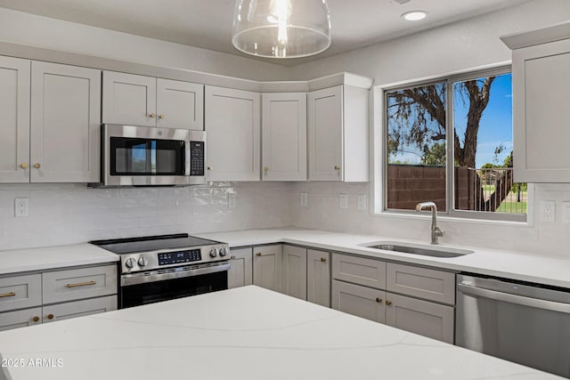 1236 S Boulder St Unit C, Gilbert, AZ 85296 - kitchen with stainless steel appliances, backsplash, gray cabinets, and light stone countertops