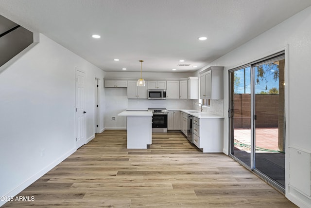 1236 S Boulder St Unit C, Gilbert, AZ 85296 - kitchen with appliances with stainless steel finishes, recessed lighting, light wood finished floors, light countertops, and a center island