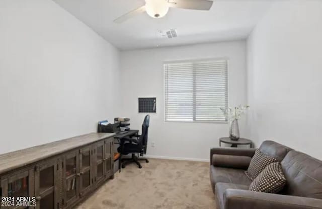 carpeted home office featuring ceiling fan