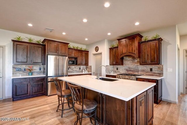 130 Brenna Dr, Chino Valley, AZ 86323 - kitchen with appliances with stainless steel finishes, a sink, recessed lighting, a kitchen island with sink, and light wood-style floors