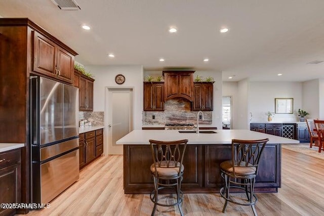 130 Brenna Dr, Chino Valley, AZ 86323 - kitchen with freestanding refrigerator, a sink, light wood-style floors, light countertops, and a center island with sink