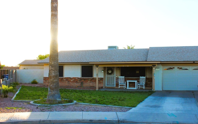 single story home featuring a garage, a porch, and a front lawn