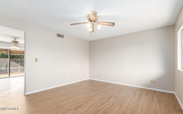 empty room featuring light hardwood / wood-style floors, ceiling fan, and a textured ceiling