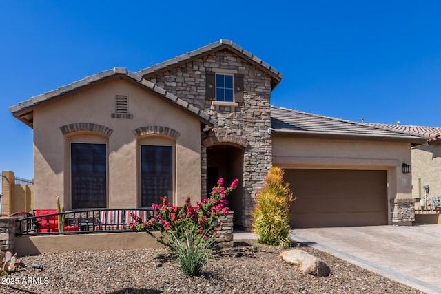 view of front facade featuring stucco siding, a tiled roof, an attached garage, driveway, and stone siding