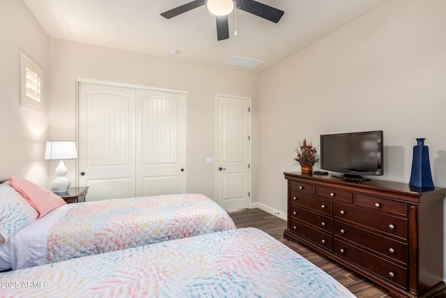 bedroom featuring a closet, dark wood-style floors, baseboards, and a ceiling fan
