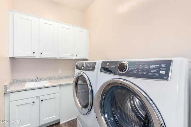 laundry area featuring washer and clothes dryer, cabinet space, and dark wood-style floors