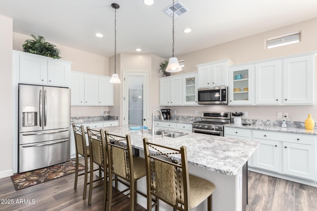 kitchen featuring appliances with stainless steel finishes, a sink, white cabinetry, dark wood-type flooring, and recessed lighting