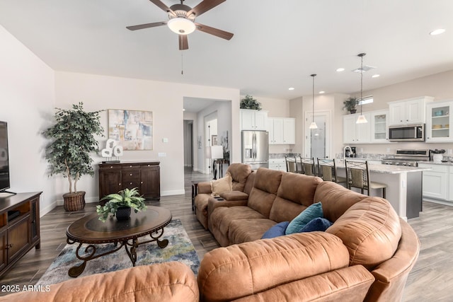 living area featuring ceiling fan, recessed lighting, wood finished floors, and baseboards