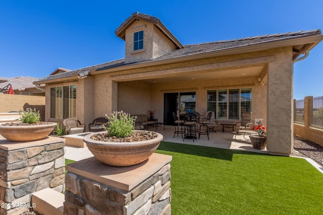 back of house featuring a patio area, stucco siding, and a tile roof