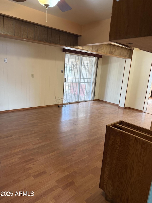 unfurnished living room with a ceiling fan and wood finished floors