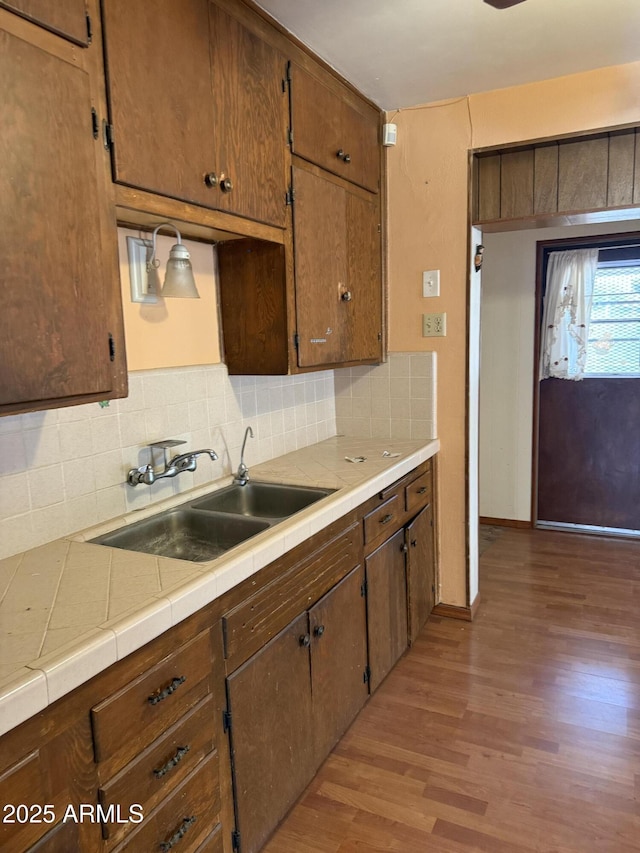 kitchen featuring a sink, backsplash, and wood finished floors