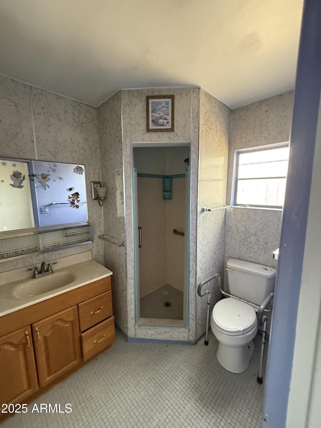 full bathroom featuring a stall shower, vanity, and toilet