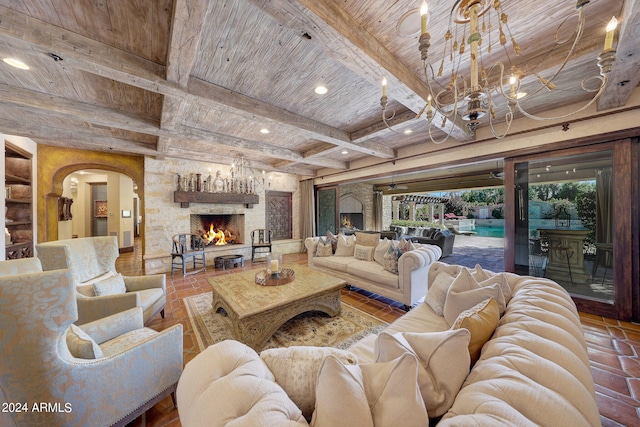 living room with a stone fireplace, beamed ceiling, and wooden ceiling