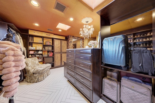 walk in closet featuring light parquet floors and a notable chandelier