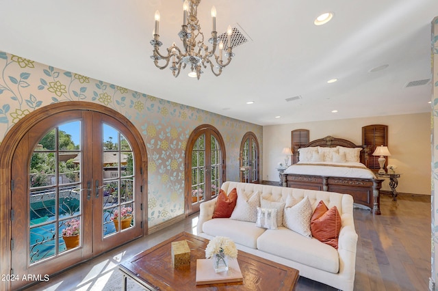 bedroom with french doors, a notable chandelier, hardwood / wood-style flooring, and access to outside