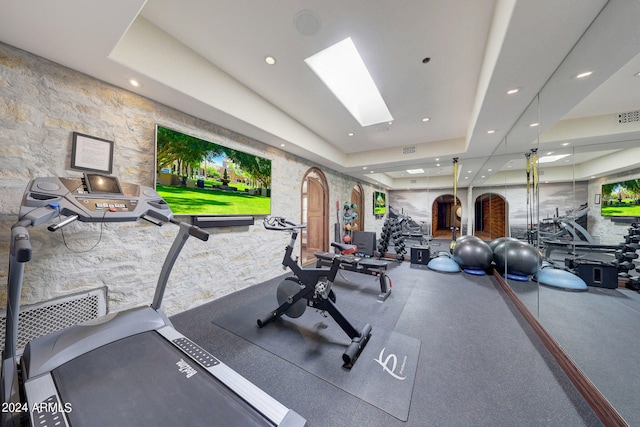 exercise room featuring a raised ceiling