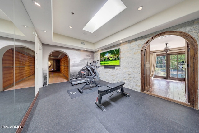 workout area with wood-type flooring and a skylight