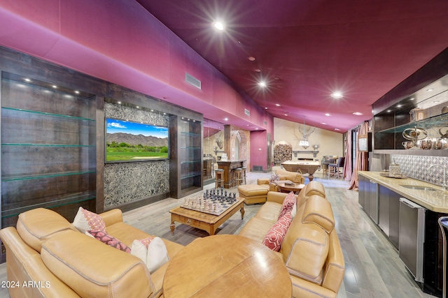 cinema room featuring light hardwood / wood-style flooring and indoor wet bar