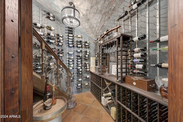 wine room with vaulted ceiling and tile patterned flooring