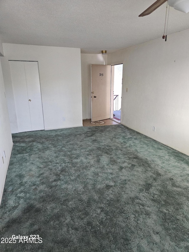 interior space featuring carpet, a ceiling fan, and a textured ceiling