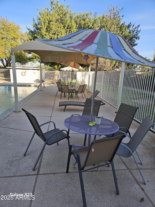 view of patio with outdoor dining space, a fenced in pool, and a fenced backyard