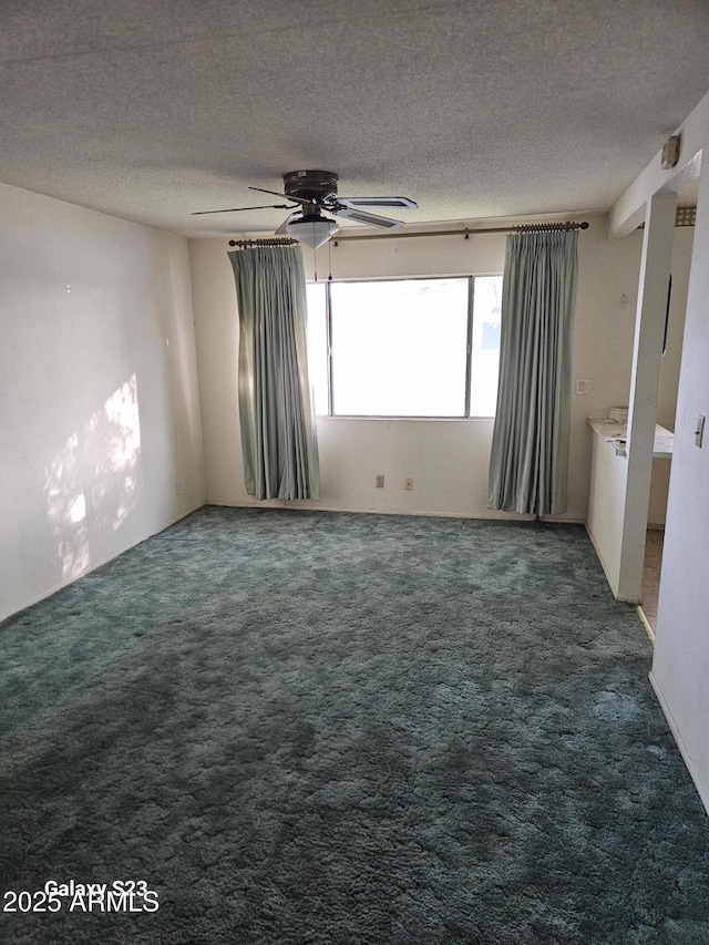 carpeted empty room featuring a textured ceiling and a ceiling fan