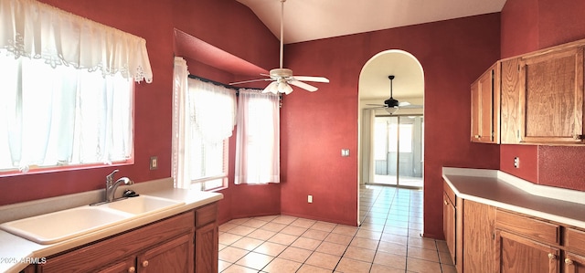 kitchen with ceiling fan, light tile patterned flooring, lofted ceiling, and sink