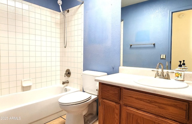 full bathroom with tile patterned floors, vanity, tiled shower / bath, and toilet