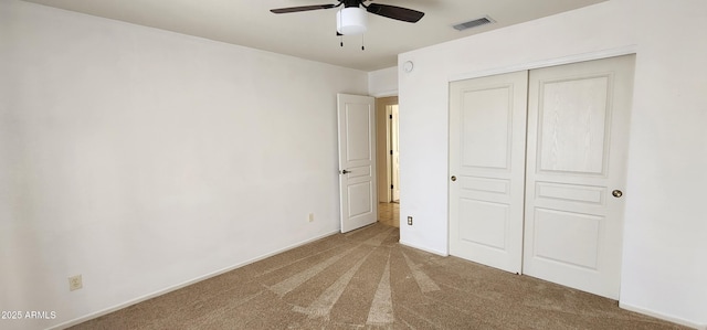 unfurnished bedroom featuring ceiling fan, a closet, and carpet