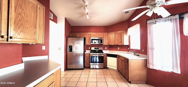 kitchen featuring plenty of natural light, ceiling fan, sink, and stainless steel appliances