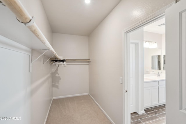 spacious closet featuring light colored carpet and visible vents