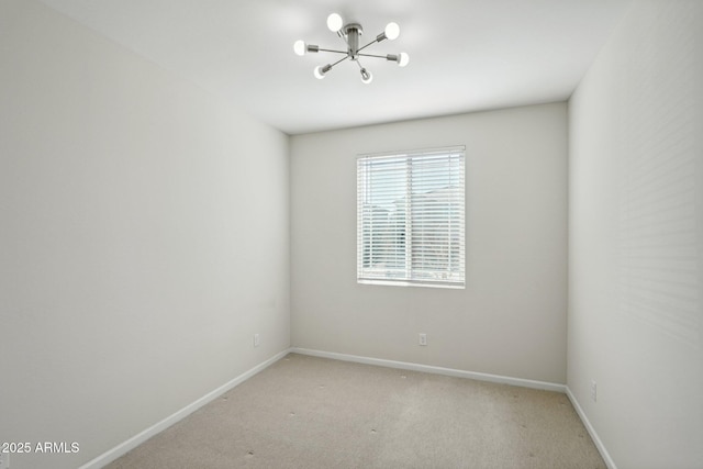 empty room with a chandelier, light colored carpet, and baseboards