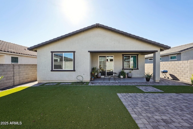 back of house featuring a patio area and a lawn