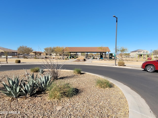 view of road with sidewalks, curbs, and street lights