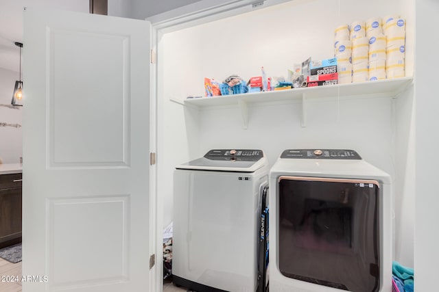 clothes washing area with washer and dryer and hardwood / wood-style flooring