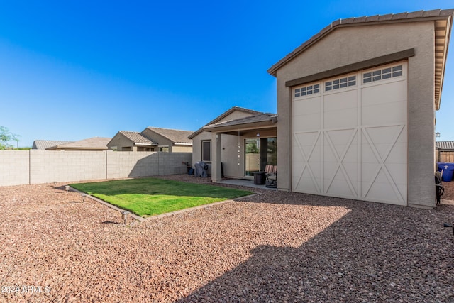 rear view of house featuring a yard and a patio