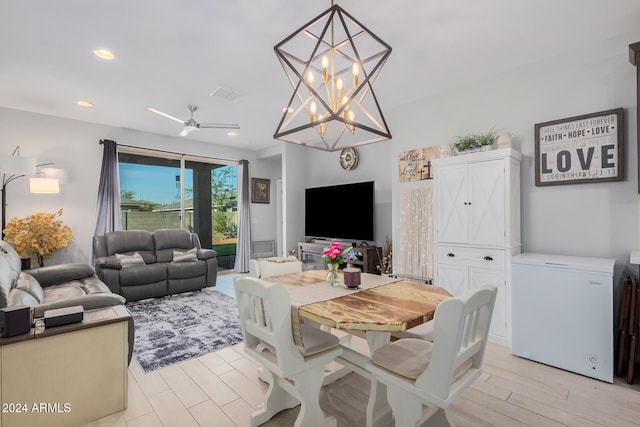 living room with light hardwood / wood-style floors and ceiling fan with notable chandelier