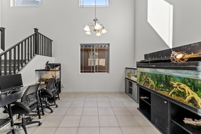 interior space with a high ceiling, light tile patterned floors, and baseboards