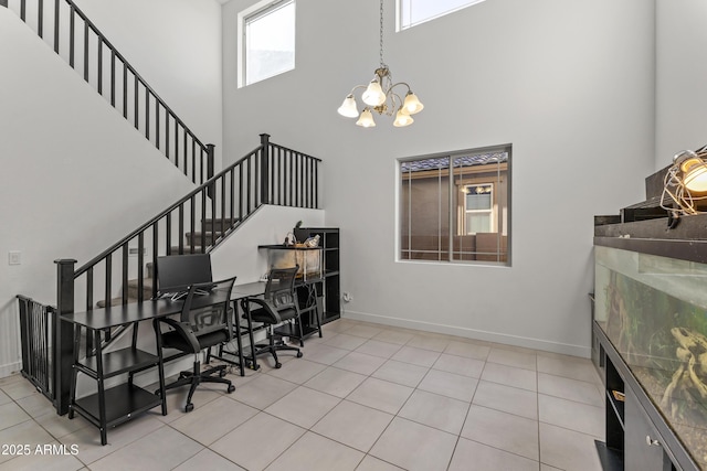 interior space featuring tile patterned floors, a high ceiling, baseboards, and a chandelier