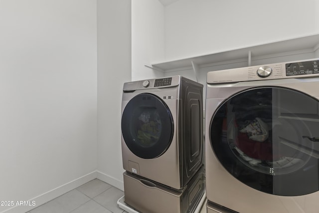 washroom featuring light tile patterned floors, baseboards, separate washer and dryer, and laundry area