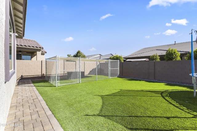 view of yard featuring a gate, a fenced backyard, and a trampoline