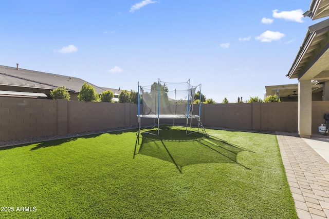 view of yard with a fenced backyard and a trampoline