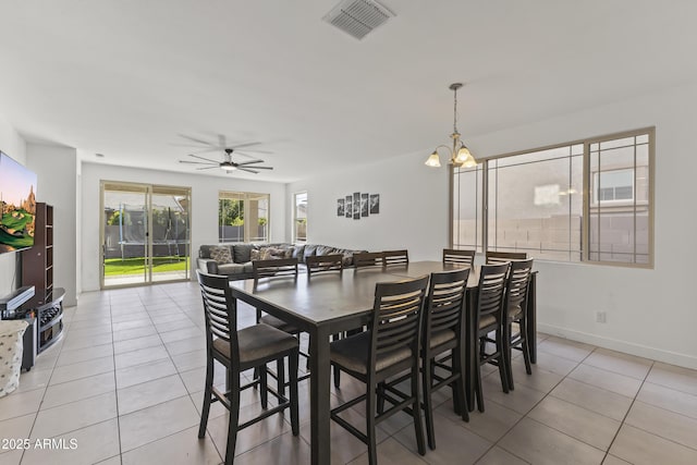 dining area featuring light tile patterned floors, visible vents, baseboards, and ceiling fan with notable chandelier